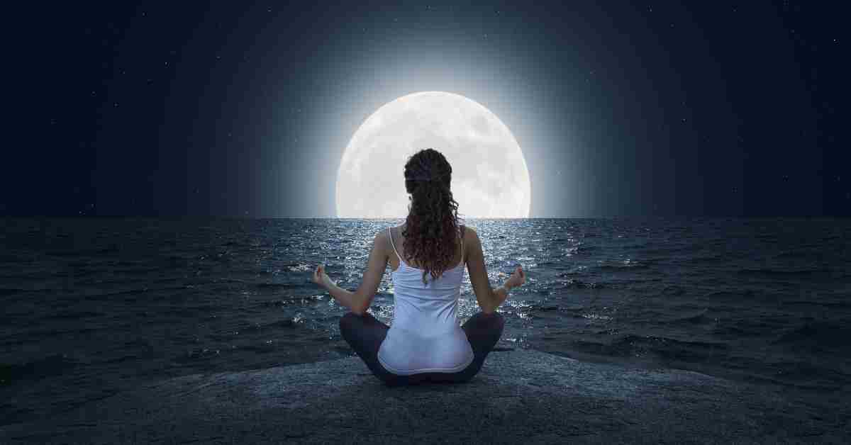 Kobieta medytująca podczas pełni księżyca