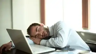 Zmęczony w pracy, usnął przy laptopie